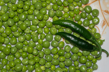 Green peas and chili on white background