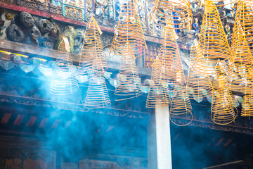 Burning spiral incense sticks hanging from the ceiling of Chua Ba Thien Hau pagoda in Ho Chi Minh, Vietnam.