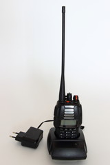 Portable radio LPD PMR transmitter in charging station on white background, walkie-talkie outdoor...