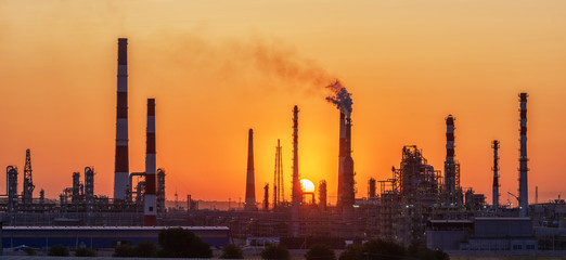 Oil refinery plant at twilight with sky background.
