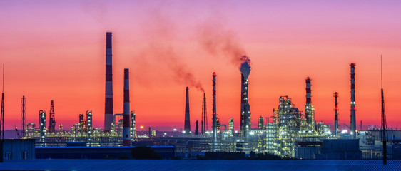Oil refinery plant at twilight with sky background.