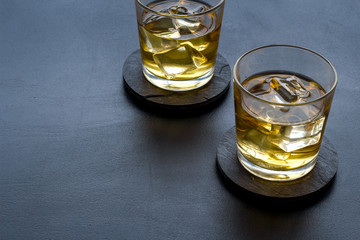 Scotch - two glasses with ice - on black background copy space