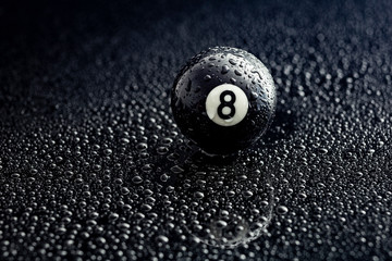 number eight billiard ball with water drops on a black background, graphic resource