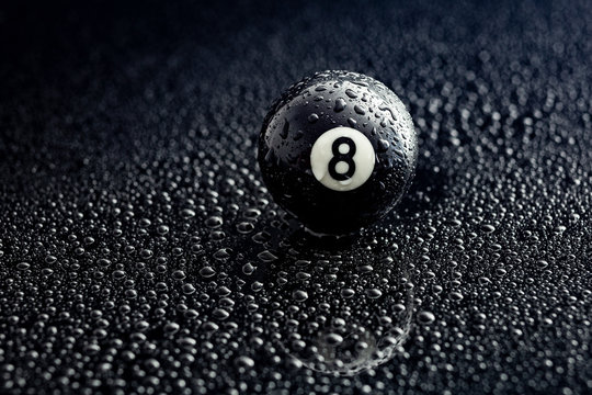 number eight billiard ball with water drops on a black background, graphic resource