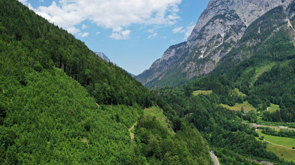 Fototapeta na wymiar Aerial view of Salzach mountainous valley around Hohenwerfen Castle. Summer landscape with fir-trees, green rocky mountains, blue sky.