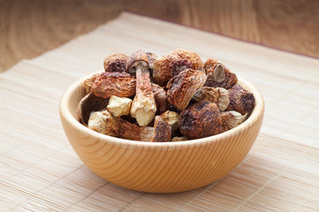 Dried Agaricus blazei mushroom in a wooden bowl on bamboo background