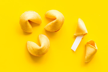 Traditional fortune cookies on yellow table top-down