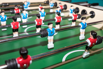 Fototapeta premium Friends Playing Table Soccer Game. table football or kicker with miniature players. game table. Games, entertainment, hobbies and leisure.foosball.plastic players in the table soccer.game kicker