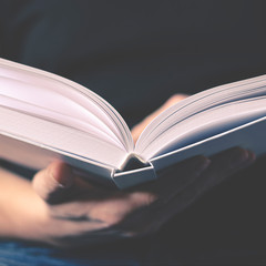 Men's hands hold a white book with clean pages