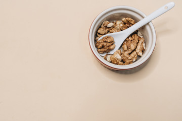 Pile of shelled walnuts in glass bowl, healthy eating concept 