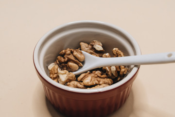 Pile of shelled walnuts in glass bowl, healthy eating concept 