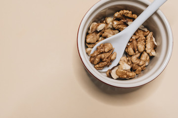 Pile of shelled walnuts in glass bowl, healthy eating concept 