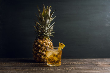 Old fahioned pineapple beverage on rustic background. Selective focus. Shallow depth of field.