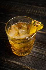 Old fahioned pineapple beverage on rustic background. Selective focus. Shallow depth of field.