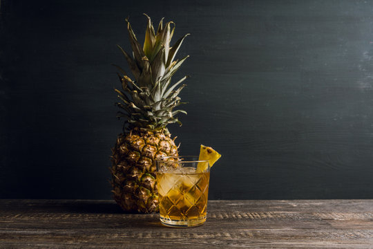 Old fahioned pineapple beverage on rustic background. Selective focus. Shallow depth of field.
