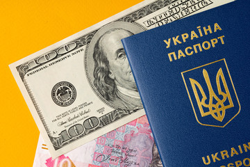 Ukrainian citizen passport with US dollars and Ukrainian hryvnia banknotes inside. Going abroad, exchange rate concept