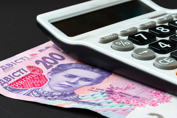 Calculator with ukrainian hryvnia banknotes close up