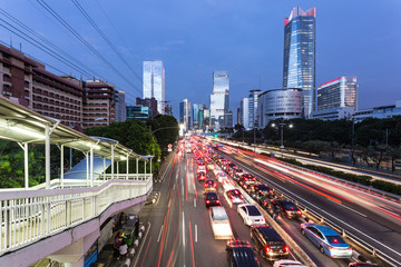 Obraz premium Rush hour in Jakarta business district in Indonesia capital city with traffic captured with blurred motion