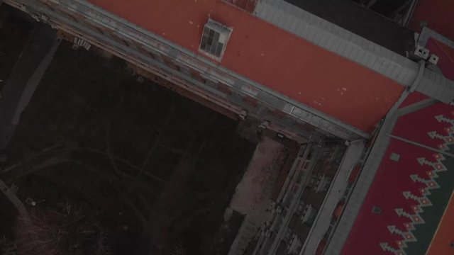 aerial flying forward drone shot above a Univerity Building in Budapest, showing the beautiful architecture of it with colorful tiles on the roof
