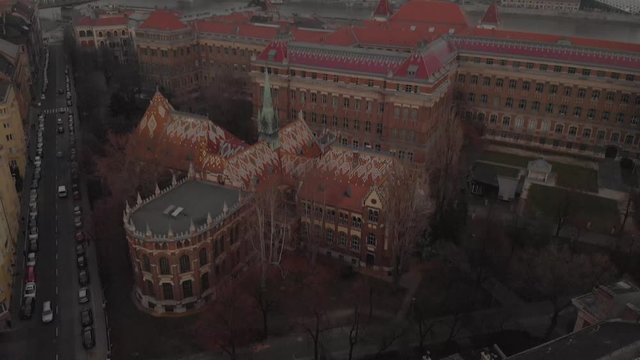aerial tilting up drone shot at a Univerity Building in Budapest, showing the beautiful architecture of it with the city in the background