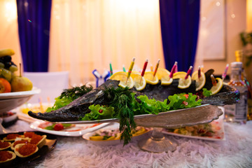 Plate with fish and lemon on banquet table 