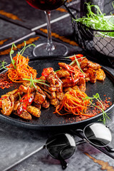 Indian kitchen. Fried chicken slices with curry sauce, hot red pepper and vegetables. Modern serving dishes in the restaurant. background image, copy space text