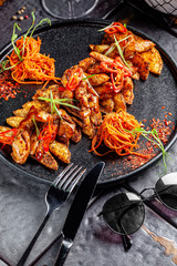 Indian kitchen. Fried chicken slices with curry sauce, hot red pepper and vegetables. Modern serving dishes in the restaurant. background image, copy space text