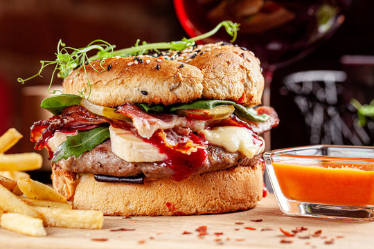 Indian kitchen. Spicy burger in an iron cage. French fries and casundi indian sauce. Modern serving dishes in the restaurant. background image, copy space text