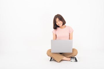 Cute Asian teen woman is working with computer on white background