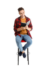 Handsome young man reading book on white background