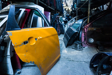 Old damaged cars on the junkyard waiting for recycling