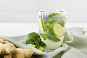 Glass of tasty ginger lemonade on table