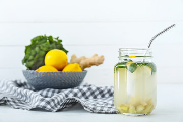 Mason jar of tasty ginger lemonade on table