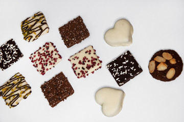 Many beautiful multi-colored cookies in chocolate on a white background
