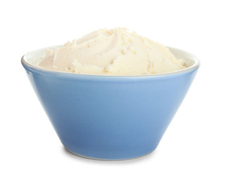 Bowl with tasty cream cheese on white background