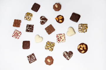 Many beautiful multi-colored cookies in chocolate on a white background