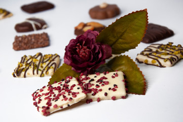 Beautiful cookies in chocolate close-up with flowers on a white background