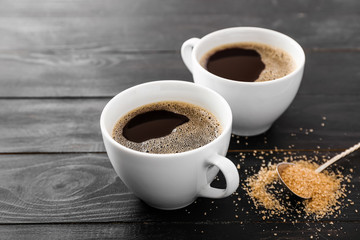 Cups of hot coffee on table