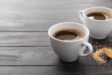 Cups of hot coffee on table