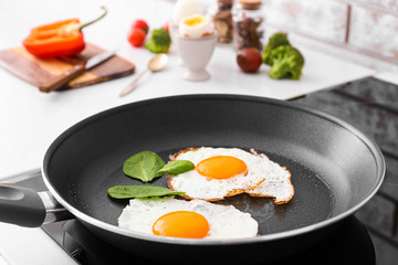 Frying pan with tasty eggs on stove