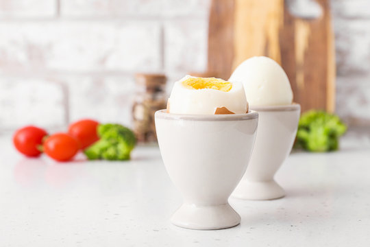 Holders with tasty boiled eggs on table