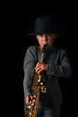 Fototapeta na wymiar happy child plays saxophone in studio