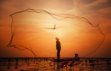 Asian Fisherman on boat fishing at lake