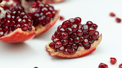 Large, ripe, juicy, peeled pomegranate slices on a white background.