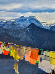Picturesque view on Everest, Nuptse mountains and buddhist colorful praying flags. At the top of Gokyo Ri at sunrise. Trekking in Solokhumbu, Nepal, Himalayas.