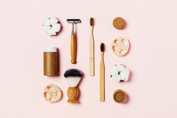 Fototapeta na wymiar Zero waste concept. Natural bamboo toothbrush, bamboo ear sticks, razor, paper tube, wooden drinking tube, natural sponge on pink background. Flat lay, top view, copy space.