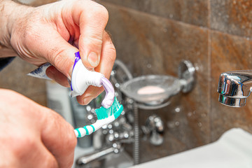 Brushing teeth. The concept of care for oral hygiene and teeth. A man reaches for a toothbrush and toothpaste. Brushing teeth after a meal.