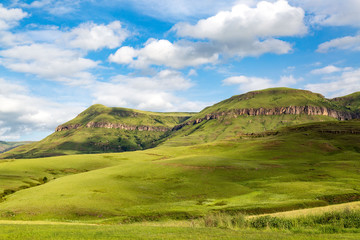 The green mountains of Maloti Drakensberg Park on a sunny day in summer with blue sky and some clouds, South Africa