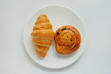 curasan and sweet bun on a white plate