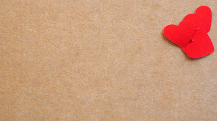 Fototapeta premium Small red hearts on brown paper with spaces for text. Concept Valentine's day and Anniversary..